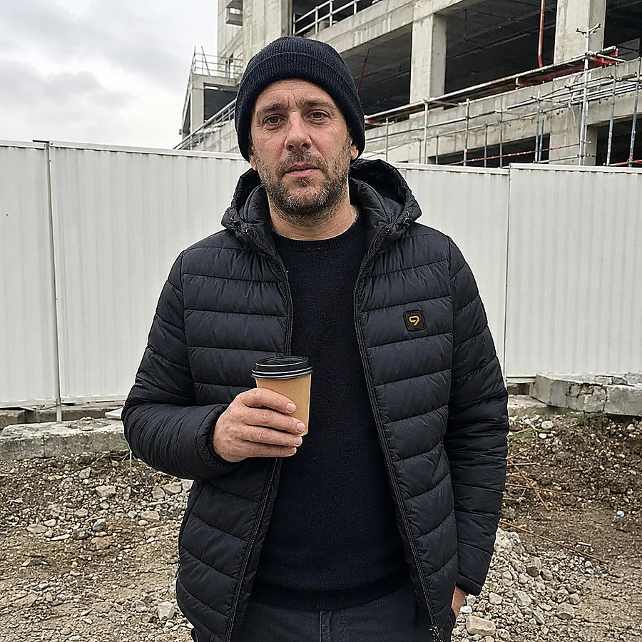 Mannlig kunde på kaffepause ute, med den oppvarmede Celsius 21-dunjakken åpen